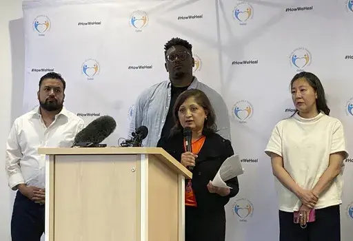 Chanda Parbhoo, at podium, founder and president of SAAVETX Education Fund, speaks at a news conference as, from left rear, Ramiro Luna, executive director and co-founder of Somos Tejas; Jerry Hawkins of Dallas Truth, Racial Healing & Transformation; and community member Caroline Kim listen, Monday, May 15, 2023, in Dallas. Members of Texas groups representing people of color demanded that authorities quickly acknowledge whether they believe the neo-Nazi who killed eight people at a Dallas-area 