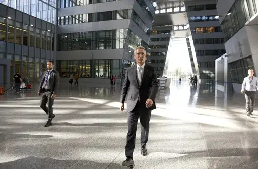 NATO Secretary General Jens Stoltenberg, center, walks in the Agora Hall as he arrives for his first day of work at the new NATO headquarters in Brussels on May 7, 2018. NATO Secretary General Jens Stoltenberg, the top civilian official at the world's biggest security alliance, routinely praises allies for helping Ukraine's troops to fight back. But when he does, Stoltenberg is talking about individual member countries, not NATO as an organization. (AP Photo/Virginia Mayo, File)