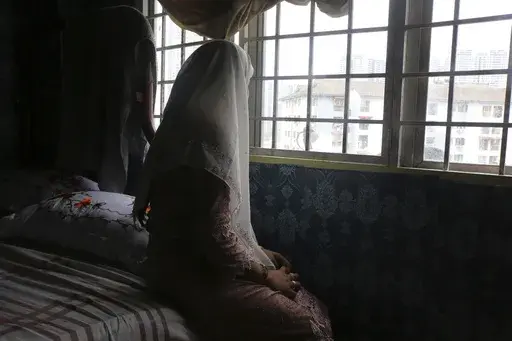 Rohingya child bride, B, age 14, sits on a bed in an apartment in Kuala Lumpur, Malaysia, on Oct. 4, 2023. B came to Malaysia in 2023 to marry an older man. Her husband wants her to get pregnant, but she says she doesn't feel ready. "I still feel like a girl." Deteriorating conditions in Myanmar and in neighboring Bangladesh’s refugee camps are driving scores of underage Rohingya girls to Malaysia for arranged marriages with Rohingya men who frequently abuse them, The Associated Press found in