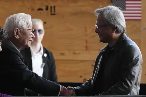 Taiwan Semiconductor Manufacturing Company founder Morris Chang, left, shakes hands with Nvidia Co-founder, President, and CEO Jensen Huang, right, at the TSMC facility under construction in Phoenix, Tuesday, Dec. 6, 2022. Nvidia shares skyrocketed early Thursday after the chipmaker forecast a huge jump in revenue for the next quarter, notably pointing to chip demand for AI-related products and services.(AP Photo/Ross D. Franklin, File)