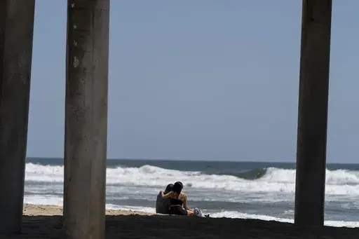 A young couple sit on the beach in Huntington Beach, Calif., Monday, May 8, 2023. For years, studies have shown a decline in the rates of American high school students having sex. That trend continued, not surprisingly, in the first years of the pandemic, according to a recent survey by the Centers for Disease Control and Prevention. The study found that 30% of teens in 2021 said they had ever had sex, down from 38% in 2019 and a huge drop from three decades ago when more than half of teens repo