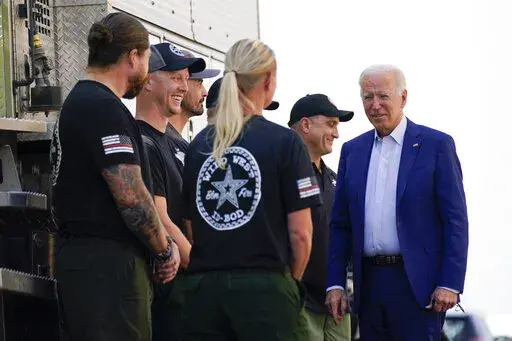 President Joe Biden greets firefighters as he tours the National Interagency Fire Center, Sept. 13, 2021, in Boise, Idaho. Biden on June 21, 2022, signed off on giving federal wildland firefighters a hefty raise for the next two fiscal years, a move that comes as much of the West is bracing for a difficult wildfire season. (AP Photo/Evan Vucci, File)