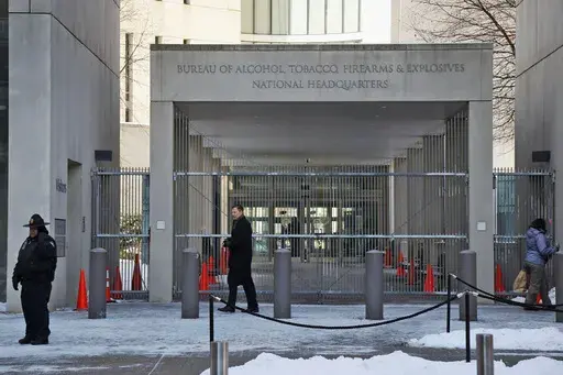 A security official walks in front of the entrance to the national headquarters of the Bureau of Alcohol, Tobacco, Firearms and Explosives on Jan. 23, 2014, in Washington. New data from the bureau shows that 68,000 illegally trafficked firearms in the U.S. came through unlicensed dealers who aren't required to perform background checks over a five year report that was released Thursday, April 4, 2024. (AP Photo/Charles Dharapak, File)